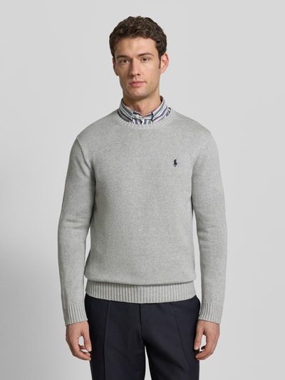 Männermodel trägt Strickpullover mit gerippten Abschlüssen von Polo Ralph Lauren, Reine Baumwolle, Regular-Fit, Rundhalsausschnitt, Label-Stitching, dezentes Grau, glatte Struktur, Ganzkörperansicht von vorne.