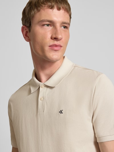 Männermodel trägt Straight Fit Poloshirt mit Label-Stitching von Calvin Klein Jeans aus reiner Baumwolle, Nahaufnahme Oberkörper.