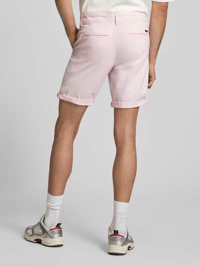Männermodel trägt Straight Fit Shorts mit Eingrifftaschen Modell 'Bowie' von Jack & Jones in Hellrosa, Rückansicht, ganzkörper. Elastischer Baumwoll-Mix, Gesäßtaschen, Knopf- und Reißverschluss, Bundweite 44 cm, Innenbeinlänge 25 cm.