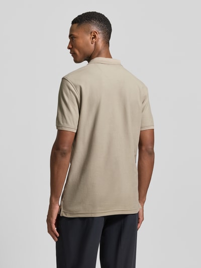 Männermodel trägt Regular Fit Poloshirt mit Logo-Stitching Modell 'Performance' von Lerros, beigefarbener Baumwoll-Mix, Ganzkörperansicht Rückansicht.