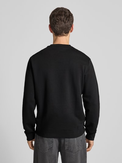 Männermodel trägt Sweatshirt mit Label-Print Modell 'Duragol' von HUGO aus reiner Baumwolle im Lockerer-Schnitt, Rückenansicht Ganzkörperansicht.
