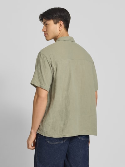 Männermodel trägt Regular Fit Freizeithemd mit Kentkragen von Jack & Jones aus Reiner Baumwolle in Hellgrün, Rückenlänge 66 cm, Schulterbreite 43 cm, Ärmellänge 24 cm, Knopfleiste, 1/2-Arm, strukturierte Oberfläche, Ganzkörperansicht Rückansicht.