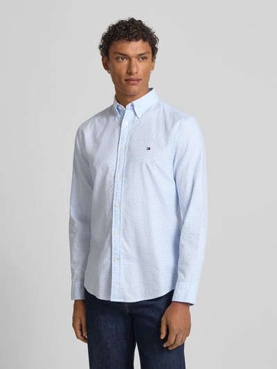 Męski model nosi Slim Fit Freizeithemd aus reiner Baumwolle od Tommy Hilfiger, efekt: wzór na całej powierzchni, popelina, koszula casualowa, krój slim fit, kołnierzyk typu button down, listwa guzikowa na całej długości, mankiet zapinany na 1 guzik, bawełna, jasnoniebieski, gładka faktura, Ganzkörperansicht von vorne.