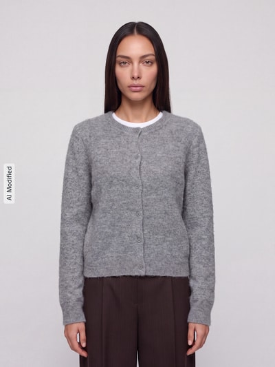 Frauenmodel trägt graue Regular Fit Strickjacke mit Woll-Anteil Modell 'MALOU' von PIECES, schlichte Struktur, Ganzkörperansicht von vorne, KI-modifiziertes Bild.