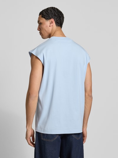Männermodel trägt Relaxed Fit Tank Top aus reiner Baumwolle Modell 'NAVERTZ' von HUGO Blue in Hellblau, unifarben, Jersey-Textur, Ganzkörperansicht Rückansicht.