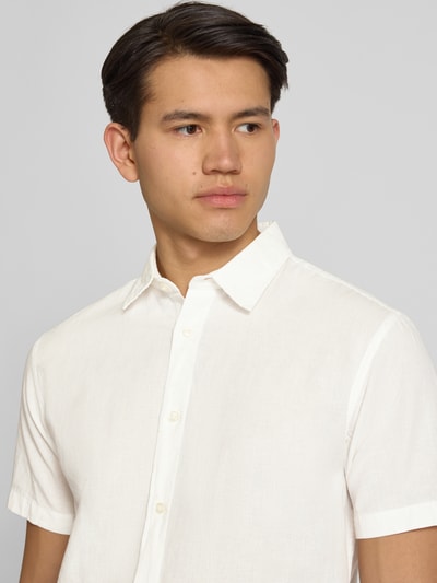 Männermodel trägt Regular Fit Freizeithemd aus Baumwoll-Leinen-Mix von Jack & Jones in Creme mit Kentkragen und Knopfleiste, Nahaufnahme Oberkörper. Rückenlänge 76 cm, Schulterbreite 50 cm, Ärmellänge 26 cm, Modell BREEZE.