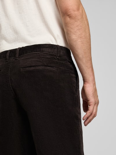 Männermodel trägt Straight Fit broek van katoenmix in corduroy look van Lindbergh, donkere bruine tinten, tekstuur zichtbaar, detailaufnahme, Bandwijdte maat M: 41 cm, Binnenbeenlengte maat M: 77 cm, steekzakken, achterzak, knoop- en ritssluiting