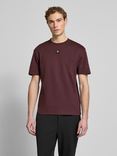 Mannelijk model draagt Regular Fit T-Shirt uit pure katoen model 'DALILE' van HUGO, effen bordeaux, labelpatch, ronde hals, korte mouw, frontale volledige lichaamsweergave.