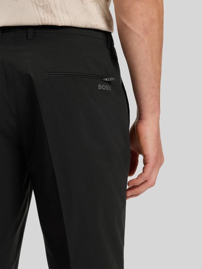 Männermodel trägt Regular Fit Shorts mit elastischem Bund Modell 'S_SPEEDFLEX' von BOSS Green, unifarben schwarz, Detailaufnahme Rückansicht.