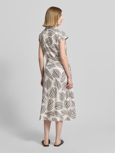 Frauenmodel trägt Midikleid aus Viskose-Mix mit Leinen-Anteil von Apricot, florales Muster in Beige und Grau, Ganzkörperansicht Rückansicht.
