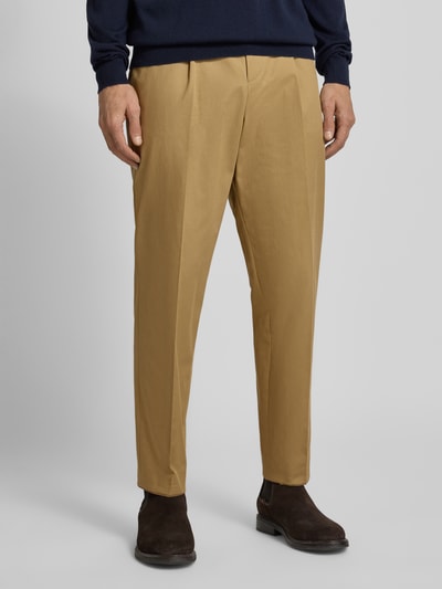 Männermodel trägt Tapered Bundfaltenhose aus Baumwoll-Mix Modell 'PERINO' von BOSS, Optik: Unifarben, Nahaufnahme Unterkörper.