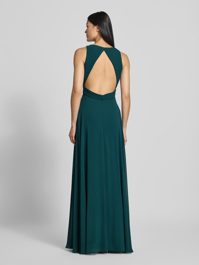 Frauenmodel trägt Fit and Flare Abendkleid mit tiefem V-Ausschnitt von Jake*s Cocktail, dunkles Grün, fließender Stoff, Ganzkörperansicht Rückansicht