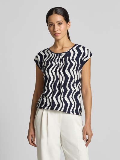 Frauenmodel trägt Relaxed Fit T-Shirt aus Viskose-Mix Modell 'Minou' von ZABAIONE mit schwarz-weißem Muster, Nahaufnahme Oberkörper. Damen T-Shirt mit Rundhalsausschnitt, Raffungen und elastischem Bund.
