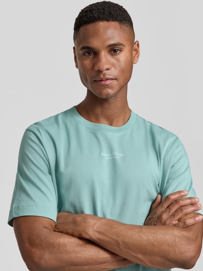 Männermodel trägt Regular Fit T-Shirt aus reiner Baumwolle von Marc O'Polo in Uni-Optik mit Label Print, Rundhals, kurzarm, Jersey-Textur, Nahaufnahme Oberkörper.