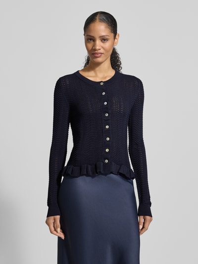 Vrouwenmodel draagt 'Strickjacke mit Rundhalsausschnitt und Wellensaum' van Christian Berg Woman Selection, materiaalmix met viscose, regular fit, ronde hals, knoopsluiting, golvende zoom, ruglengte maat 36: 53 cm, mouwlengte maat 36: 67 cm, effen donkerblauw, golvende structuur, geheelbeeld van voren.