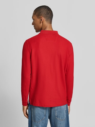 Männermodel trägt Regular Fit Langarm-Poloshirt mit Label-Stitching von Fynch-Hatton in Rot, reine Baumwolle, Ganzkörperansicht Rückansicht.