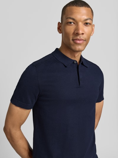 Männermodel trägt Regular Fit Poloshirt aus reiner Baumwolle Modell 'BERG' von SELECTED HOMME, Optik: Unifarben, Nahaufnahme Oberkörper.