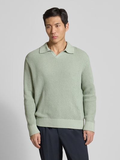 Männermodel trägt Relaxed Fit Strickpullover aus reiner Baumwolle Modell 'DERECK' von SELECTED HOMME, grob gestrickt, unifarben, Hemdkragen, Rippbündchen, Ganzkörperansicht von vorne.