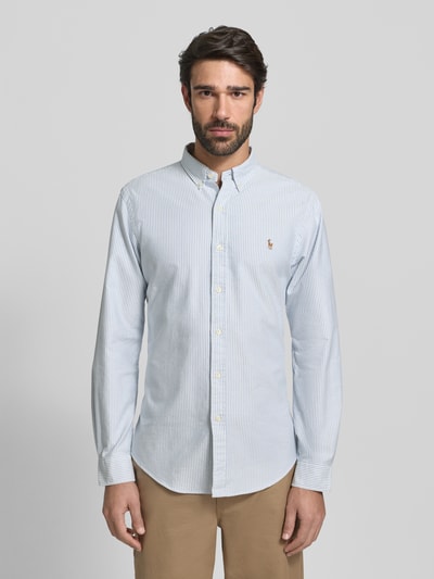 Männermodel draagt Slim Fit vrijetijdsoverhemd uit puur katoen model 'OXFORD' van Polo Ralph Lauren, verticale strepen, button-downkraag, doorlopende knoopsluiting, labelstitching, met lange mouwen, ruglengte maat M 79 cm, schouderbreedte maat M 43 cm, mouwlengte maat M 66 cm, kleuren lichtblauw en wit, gladde textuur. Ganzkörperansicht van voren.