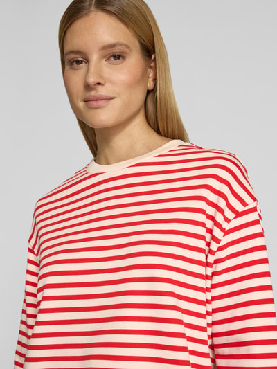 Modelka nosi Oversized Sweatshirt aus reiner Baumwolle Modell 'FRANKAA MAARLEN STRIPE' von Armedangels, dwukolorowe, drobny prążek, okrągły dekolt, długi rękaw, aplikacja z napisem, jednolity wzór, czysta bawełna, zbliżenie na górną część ciała