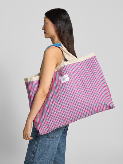 Kobieta modelka nosi Beach Bag mit Logo-Patch Modell 'Poplin' od STUDIO NOOS w kolorowe paski, główna przegroda, pasek na ramię, naszywka z logo, szerokość w rozmiarze 1: 58 cm, długość w rozmiarze 1: 46 cm, głębokość w rozmiarze 1: 52 cm, długość paska na ramię w rozmiarze 1: 9 cm, ujęcie całej sylwetki z boku.