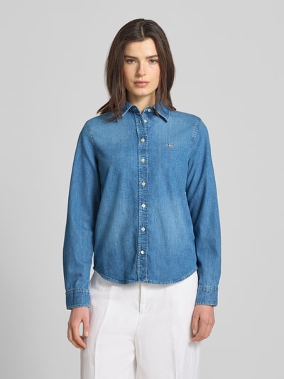 Vrouwenmodel draagt Jeansbluse mit Logo-Stitching und Sportmanschetten van Gant in regular fit, blauwe katoen, kentkraag, knoopsluiting, afgeronde zoom, vooraanzicht volledige opname