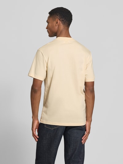Männermodel trägt Regular Fit T-Shirt aus reiner Baumwolle von Lacoste in Unifarbe mit Logo-Print, Rückansicht Ganzkörperansicht.