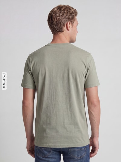 Männermodel trägt T-Shirt mit Rundhalsausschnitt von MCNEAL, Slim Fit, reine Baumwolle, dezentes Grün, Ganzkörperansicht Rückansicht.