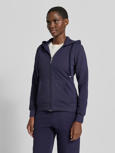 Frauenmodel trägt Regular Fit Sweatjacke aus Baumwoll-Mix von Christian Berg Woman in dunklem Blau mit Kapuze und Känguru-Tasche, Ganzkörperansicht von vorne.