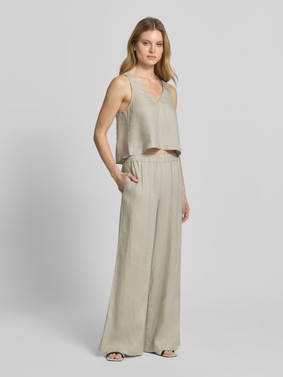 Frauenmodel trägt Leinenhose mit elastischem Bund von Style Icon Collection in Beige, weiter Schnitt, Struktur aus reinem Leinen, Ganzkörperansicht von vorne.