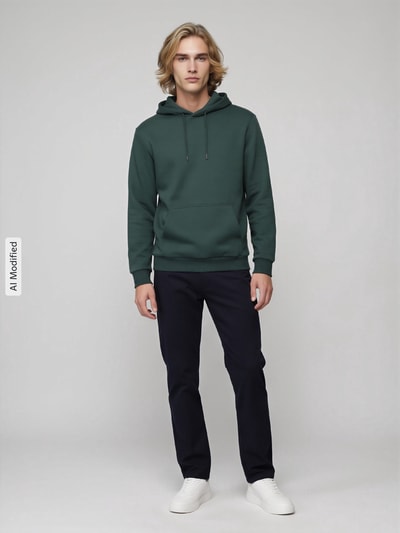 Mężczyzna model nosi Regular Fit Hoodie aus Baumwoll-Mix model 'CERES' od ONLY, zielony, czarne spodnie, jasne buty, zdjęcie całopostaciowe z przodu, bluza z kapturem dla mężczyzn od ONLY & SONS, KI-modifiziertes Bild.