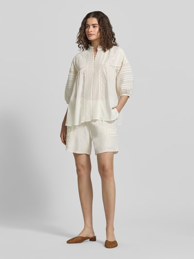 Kobiece model nosi Relaxed Fit Bluse mit Stitchings und Drapierungen od Jake*s Casual z mieszanki bawełny i wiskozy, kremowa, stójka, listwa guzikowa, hafty, koronka, drapowania, rękaw o dł. 3/4, długość tyłu w rozmiarze 38: 62 cm, długość rękawów w rozmiarze 38: 25 cm, widok całej sylwetki z przodu.