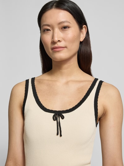 Frauenmodel trägt Slim Fit Tank Top aus Viskose-Mix Modell 'BARDOT' von Vero Moda, cremefarben, Rippstrick, U-Ausschnitt, Nahaufnahme Oberkörper.