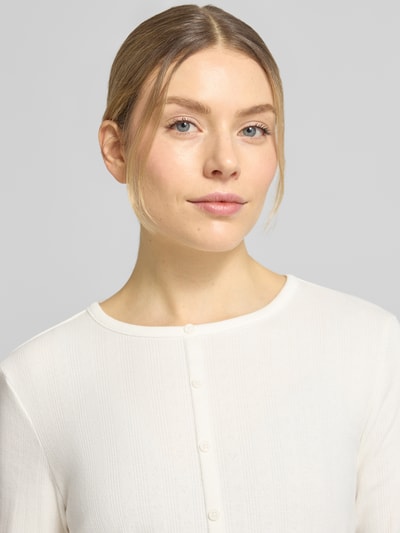 Frauenmodel trägt Shaped Fit Langarmshirt aus Baumwoll-Mix von Tom Tailor Denim, Optik: Unifarben, gestreifte Struktur, Label-Stitching-Applikation, Rundhals, langarm, Ärmelabschluss und Rumpfabschluss mit Frill, Jacquard Materialverarbeitung, Nahaufnahme Oberkörper.
