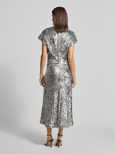 Vrouwenmodel draagt Maxikleid met Pailletten- en Ziersteinbesatz van Rich & Royal in zilveren kleur, elastische materiaalmix, getailleerd, ronde hals, met korte mouwen, maxilengte, naadritssluiting achter, ruglengte maat 36: 135 cm, borstwijdte: 48 cm, mouwlengte: 23 cm. Ganzkörperansicht Rückansicht.