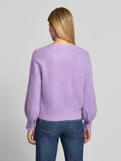 Frauenmodel trägt Regular Fit Pullover aus Kaschmir-Mix mit Woll-Anteil von HERZENS in zartem Lila, Strick-Optik, elastische Ärmel, Ganzkörperansicht Rückansicht.