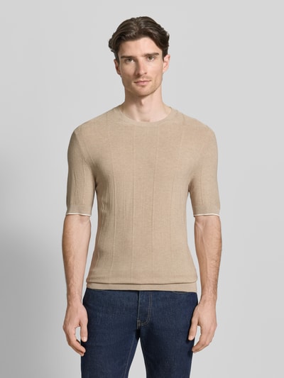 Męski model nosi Strickshirt mit Viskose-Anteil Modell 'Gion' od CINQUE, beżowy, prosty krój, okrągły dekolt, półrękaw, widok całej sylwetki z przodu.