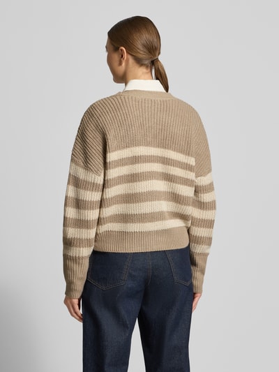 Vrouwenmodel draagt Relaxed Fit Strickjacke mit V-Ausschnitt Modell 'LEA' van Vero Moda in melangelook, gebreid, lange mouw, rompzoom geribd. Ganzkörperansicht van achteren.