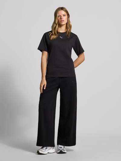 Frauenmodel trägt Relaxed Fit T-Shirt aus reiner Baumwolle von PUMA in Schwarz, glatte Textur, Ganzkörperansicht von vorne, Damen T-Shirt von PUMA