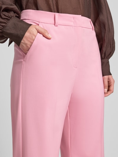 Frauenmodel trägt Stoffhose aus Viskose-Mix mit Gesäßleistentasche von Comma, rosa, französische Eingrifftaschen, Haken- und Reißverschluss, Bügelfalten, Nahaufnahme Oberkörper.
