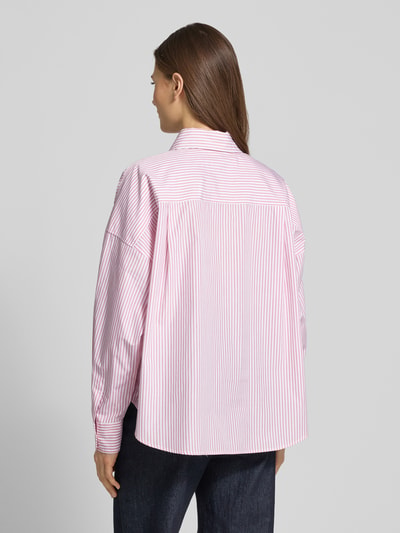 Modelka nosi Oversized Hemdbluse aus reiner Baumwolle Modell 'AUREO' od Weekend Max Mara, różowo-białe paski, długi rękaw, widok z tyłu