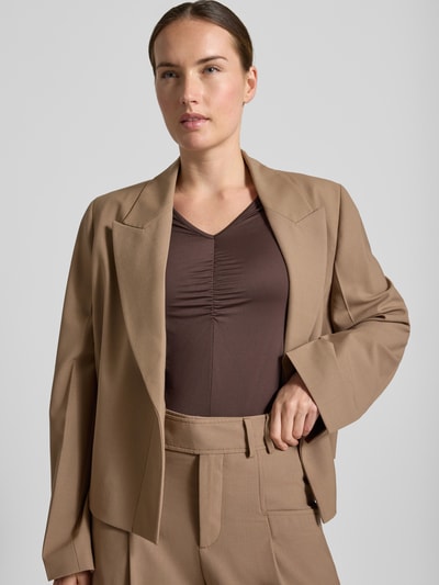 Frauenmodel trägt Langarmshirt mit abgerundetem Rumpfabschluss von MARC CAIN in Braun, körpernah, V-Ausschnitt, Raffung, Nahaufnahme Oberkörper.