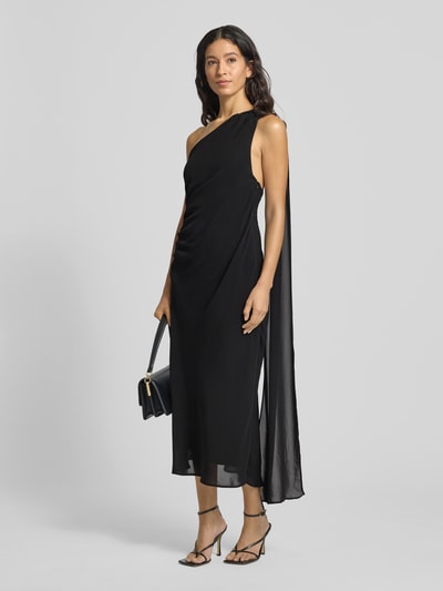 Frauenmodel trägt Midikleid mit Neckholder Modell 'EVA' von Mango in Schwarz, taillierter Schnitt, mit Raffungen und One-Shoulder-Träger, blickdichtes Unterkleid, Ganzkörperansicht von vorne.