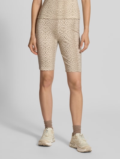 Frauenmodel trägt Radlerhose im Allover-Look Modell 'Roxie' von OH APRIL in Beige mit Leopardenmuster, Lyocell-Elasthan-Mix, körpernahe Passform, Ganzkörperansicht von vorne.