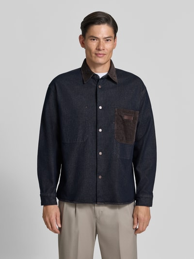 Männermodel trägt dunkelblaues Overshirt mit Kentkragen in Cord-Optik und Label-Patch von Armani Exchange, Regular fit, Knopfleiste, Brusttasche, Sportmanchetten, Rückenlänge 70 cm, Ganzkörperansicht von vorne.