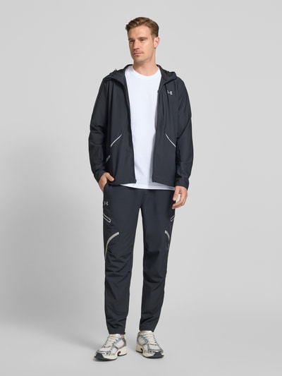 Männermodel trägt Regular Fit T-Shirt mit Logo-Applikation von Under Armour aus Baumwoll-Mix, schlichtes Weiß, Ganzkörperansicht von vorne.