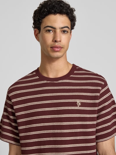 Männermodel trägt Strukturiertes T-Shirt mit Logostickerei auf der Brust von REVIEW in Braun mit Strukturmuster, Reine Baumwolle, Nahaufnahme Oberkörper.