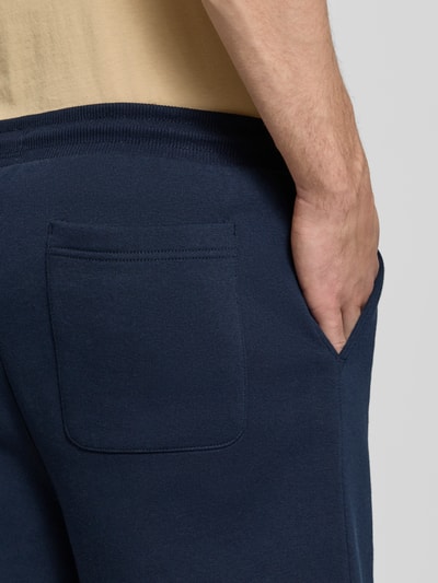 Mężczyznamodel nosi Regular Fit Shorts aus Baumwoll-Mix von Tommy Jeans, efekt: jednolity kolor, detal z logo, tunel, elastyczny ściągacz, kieszeń z tyłu, wpuszczane kieszenie, wykończenie: dzianina dresowa, mieszanka bawełny, zbliżenie na tylną część ciała