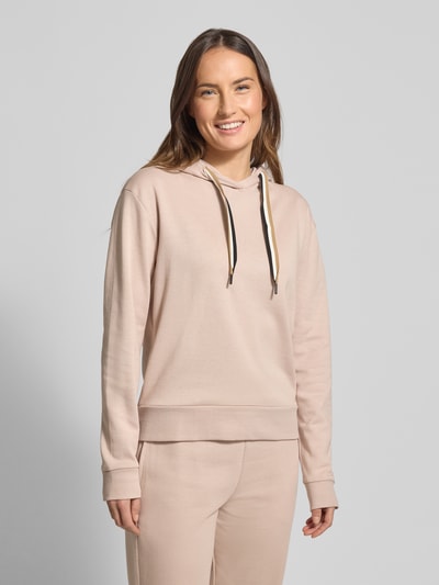 Vrouwenmodel draagt Regular Fit Hoodie uit lyocellmix van BOSS, look: effen, pasvorm: regular fit, labelprint, lange mouw, capuchon met tunnelkoord, detailopname bovenlichaam.