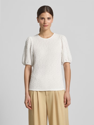 Frauenmodel trägt Blusenshirt mit Strukturmuster Modell 'FALL' von Vila aus weißem Material-Mix mit Stretch-Anteil, Regular-Fit, Nahaufnahme Oberkörper.